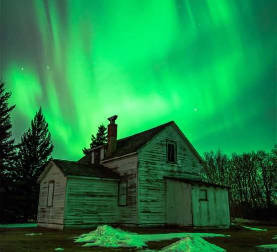 Aurora Borealis dances over an abandoned house in the Saskatchewan landscape