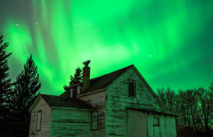 Aurora Borealis dances over an abandoned house in the Saskatchewan landscape