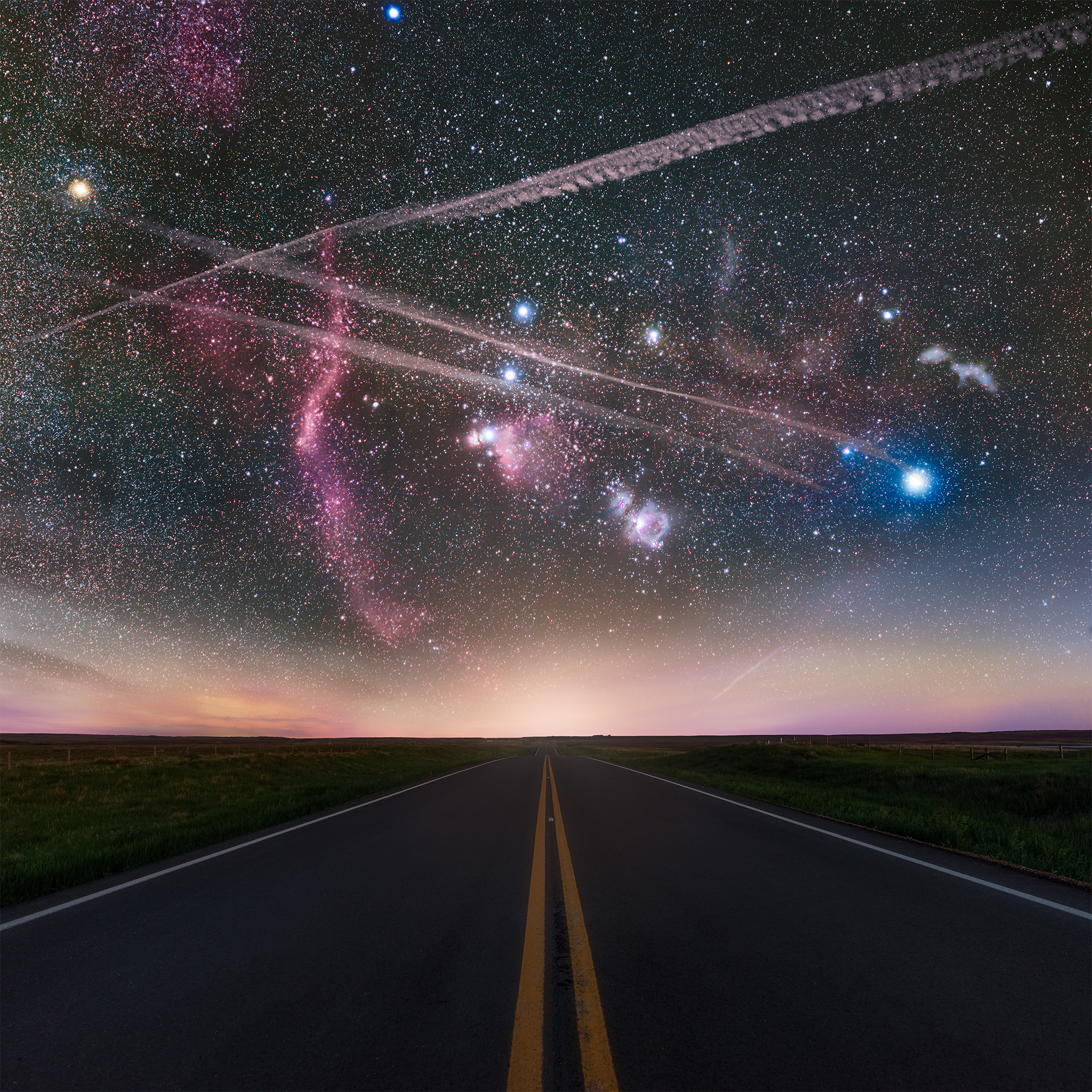 Landscape astrophotography in Saskatchewan of the Orion constellation over a road