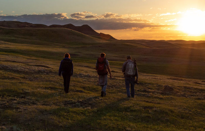 Three students participating in a landscape photography workshop in Grasslands National Park, Saskatchewan.