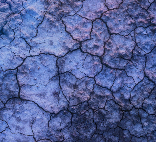 Abstract photography of mud cracks in Saskatchewan reflecting twilight colours.