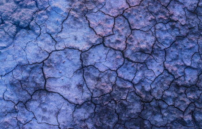 Abstract photography of mud cracks in Saskatchewan reflecting twilight colours.