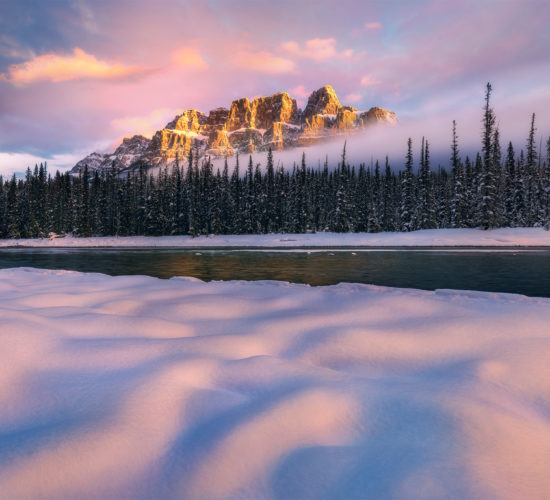 A landscape photograph of a beautiful sunrise at Castle Mountain in the winter