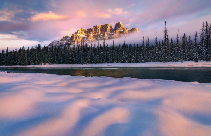 A landscape photograph of a beautiful sunrise at Castle Mountain in the winter