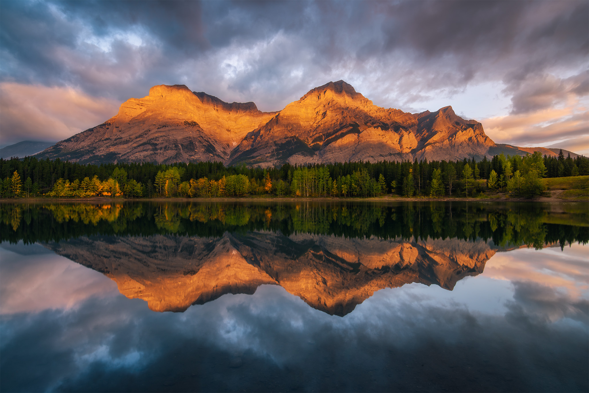 A landscape photograph taken during sunrise at Wedge Pond in the Canadian Rockies
