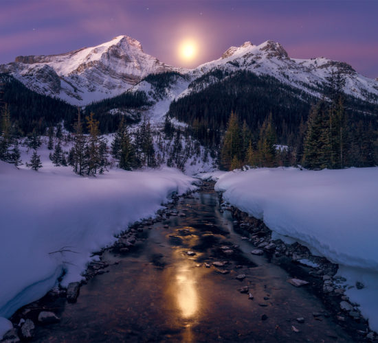 A landscape photograph in the Canadian Rockies of moonset over a Mt Murray
