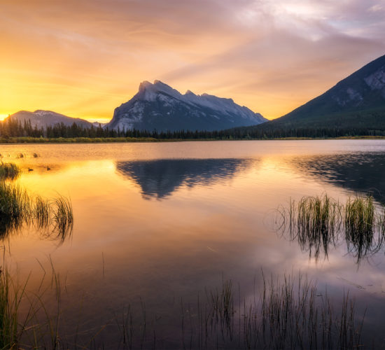 A landscape photograph of Vermilion Lakes in Banff National Park at sunrise