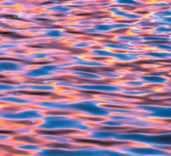 An intimate landscape photograph of reflected light on ripples of water at Maligne Lake in Jasper National Park