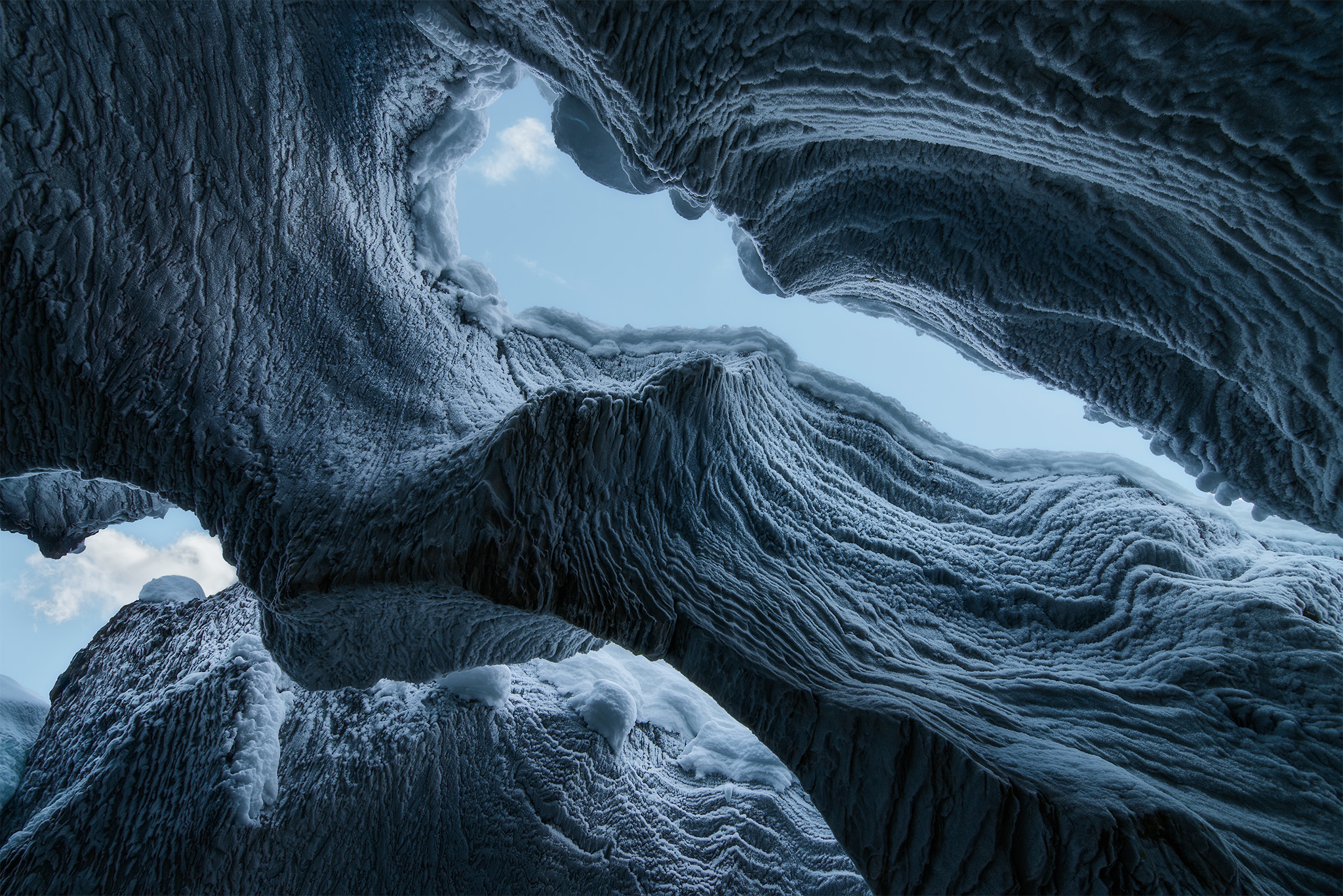 An intimate landscape photograph of Natural Bridge in Yoho National Park at winter. Looking up from inside the ice cave.