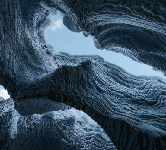 An intimate landscape photograph of Natural Bridge in Yoho National Park at winter. Looking up from inside the ice cave.