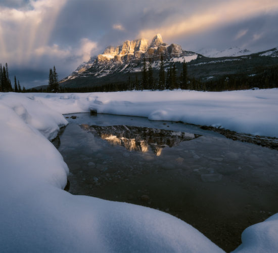 A landscape photograph of Castle Mountain with a beam of light illuminating the mountain