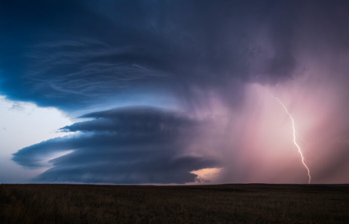 A photograph of a supercell thunderstorm on the Canadian prairie with lightning in the hail core