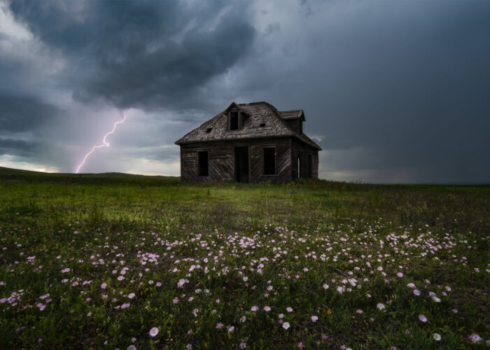 A storm photograph of an abandoned house in south Saskatchewan with lightning behind