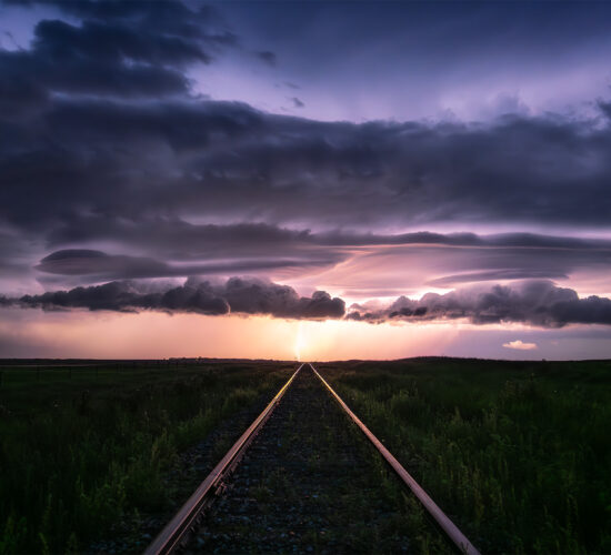 A storm photograph of a lightning strike at the end of a railroad