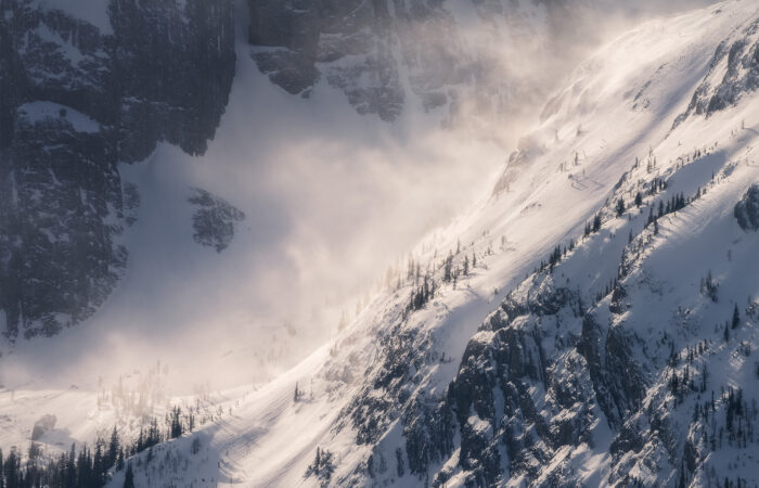 An intimate scene of snow blowing off a mountain peak in Kananaskis Country