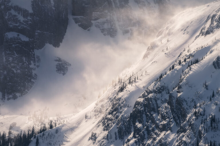 An intimate scene of snow blowing off a mountain peak in Kananaskis Country