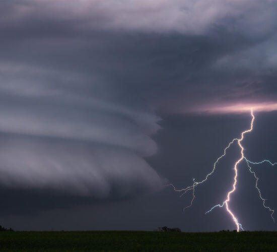 A storm image of a lightning strike beside great supercell structure