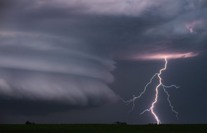 A storm image of a lightning strike beside great supercell structure